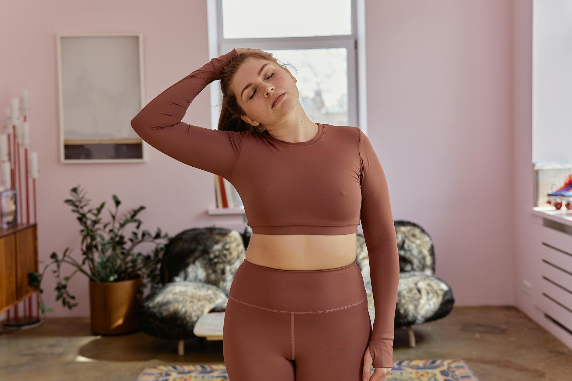 Kobieta plus size w stroju sportowym rozciąga się w domu po chorobie