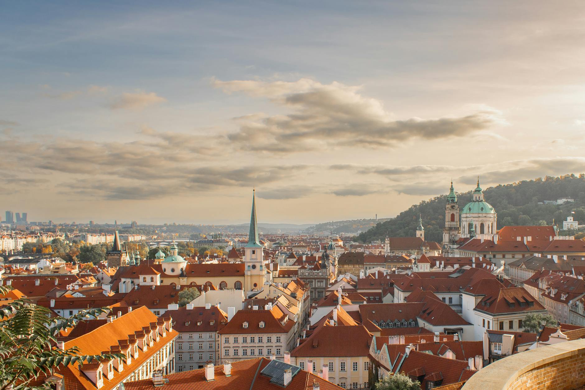 Panorama historycznego centrum Pragi z czerwonymi dachami o zachodzie słońca