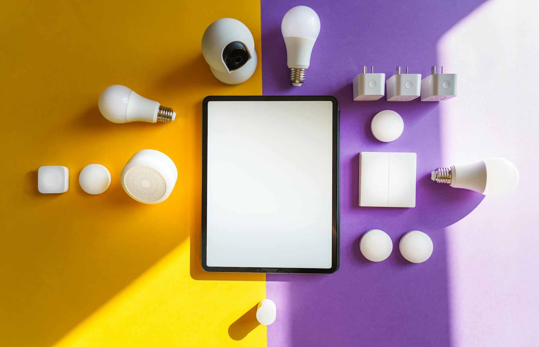 Zestaw urządzeń smart home i tablet na żółto-fioletowym tle