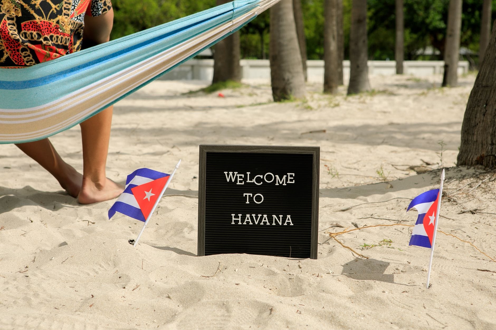 Kuba na własną rękę: praktyczny przewodnik po zwiedzaniu wyspy, plażach i lokalnych atrakcjach Plaża na Kubie z hamakiem, flagami kubańskimi i napisem Welcome to Havana